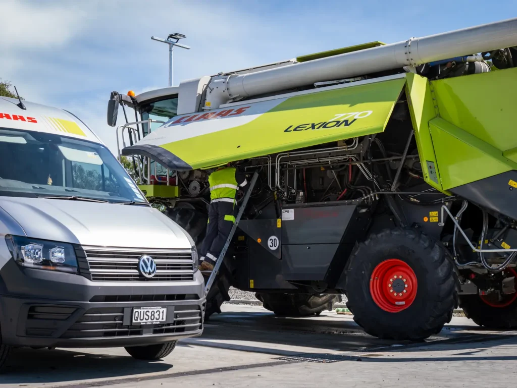 Service technician working under the side panel of LEXION